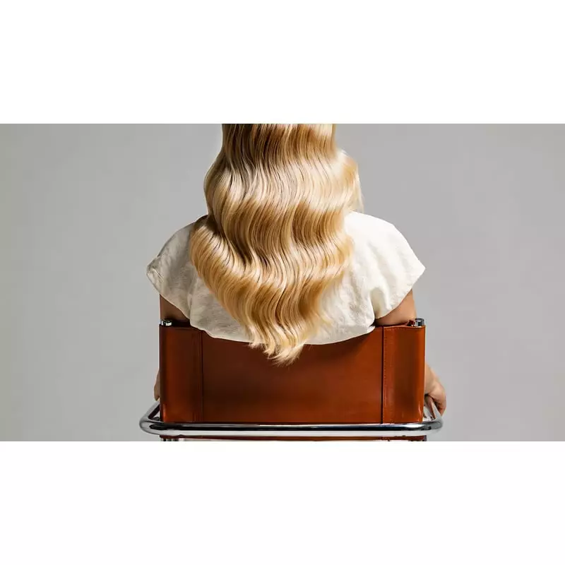 Femme aux cheveux brillants après le shampoing Lazartigue Clear DS, visiblement sans pellicules.