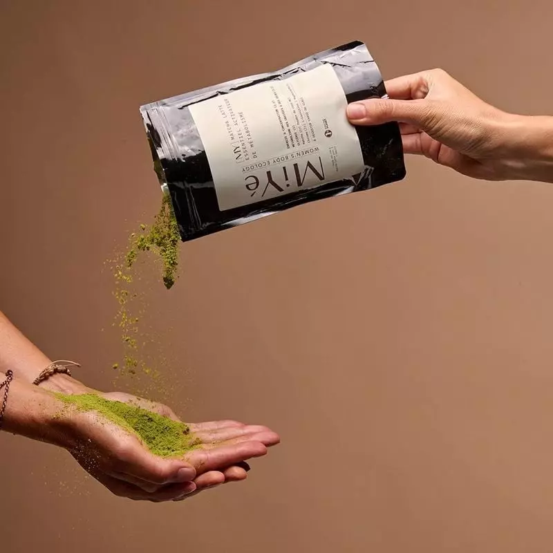 Photo lifestyle d'une femme tenant un verre de MiYé Matcha Latte en travaillant à son bureau