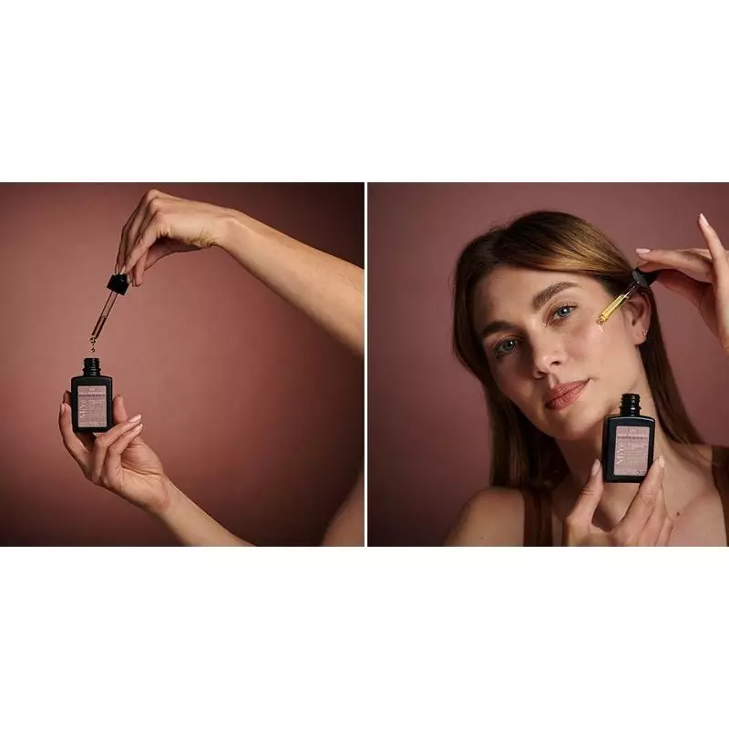 Femme appliquant l'huile régénérante MiYé sur sa joue dans une salle de bain lumineuse, souriant dou