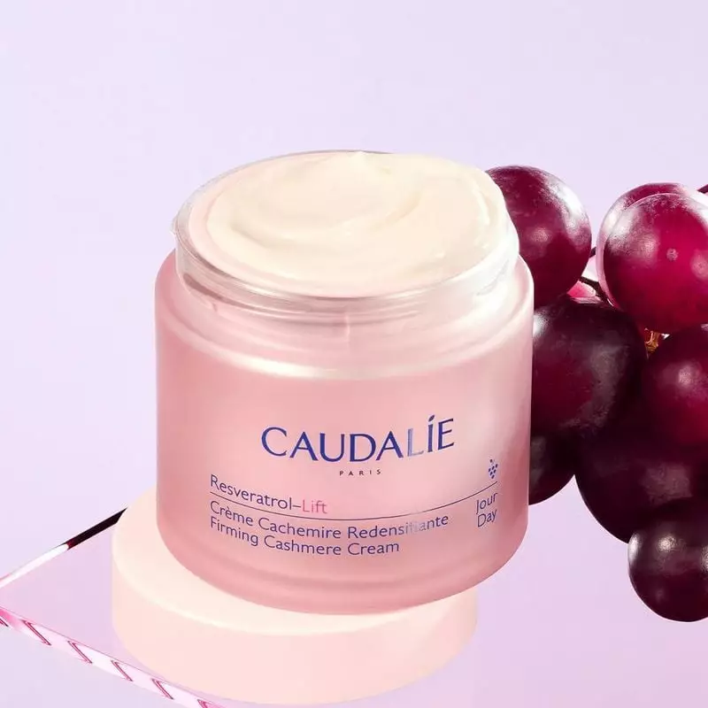 Pot ouvert de la Crème Cachemire Redensifiante Resveratrol-Lift Caudalie, texture blanche et raisins