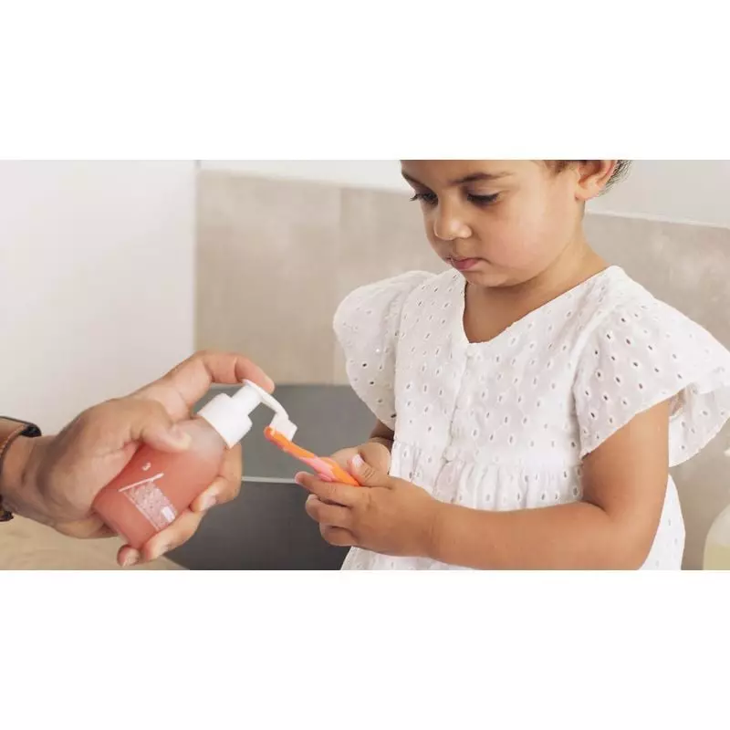 Enfant souriant se brossant les dents avec WhatMatters Dentifrice enfant bio fraise recharge - 180ml