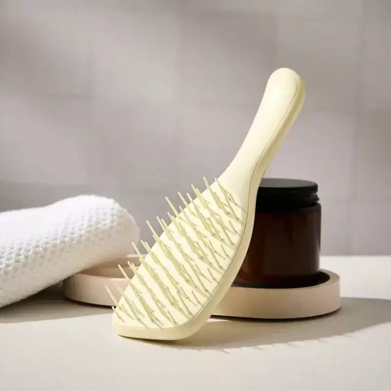 Tangle Teezer The Ultimate Detangler jaune camomille sur un plateau de salle de bain avec serviette 