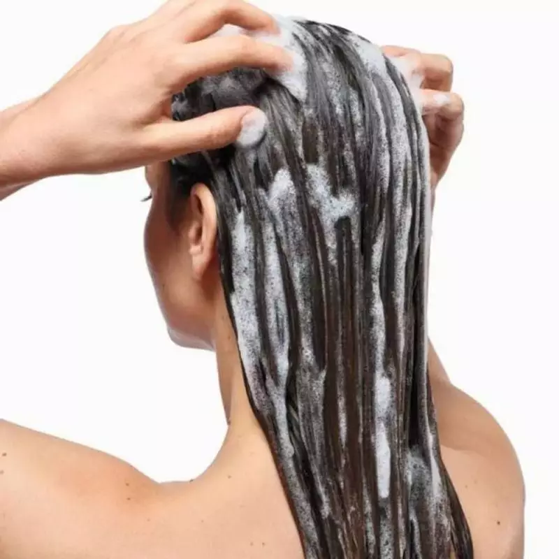 Le Klorane Shampoing Galanga anti-pelliculaire 2x400ml dans une salle de bain lumineuse, à côté d'un