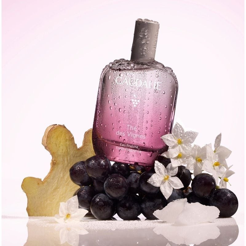 Flacon Caudalie Thé des Vignes 50 ml avec gouttes d'eau sur raisins, racine de gingembre et fleurs b