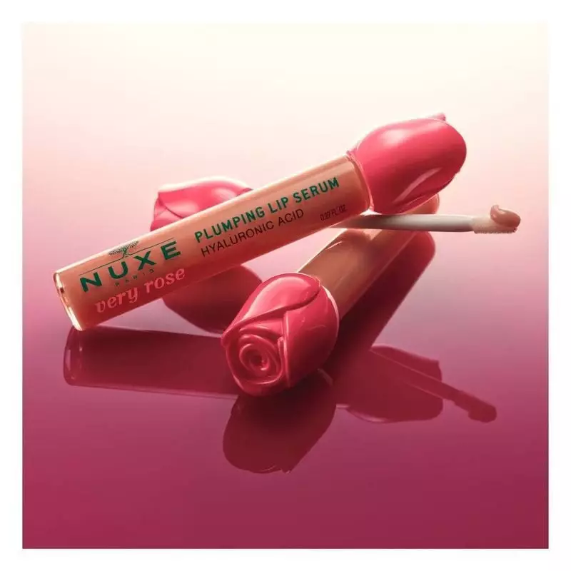 Sérum lèvres repulpant Nuxe Very Rose avec bouchon en forme de rose et applicateur sur fond rose