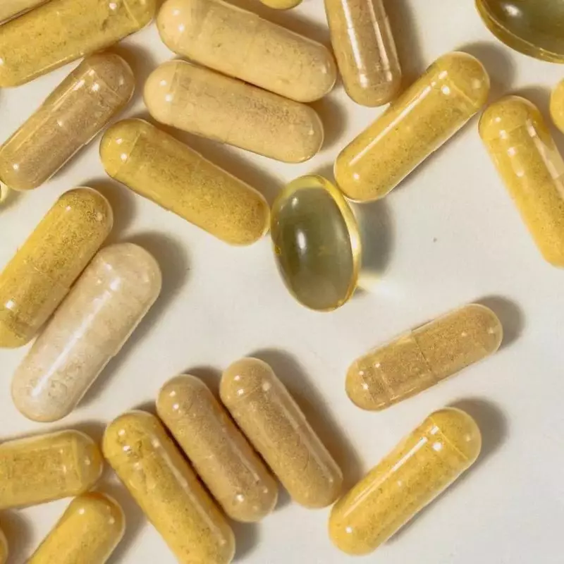 Gros plan sur des gélules beiges Hollis Intime et une capsule molle dorée sur fond clair