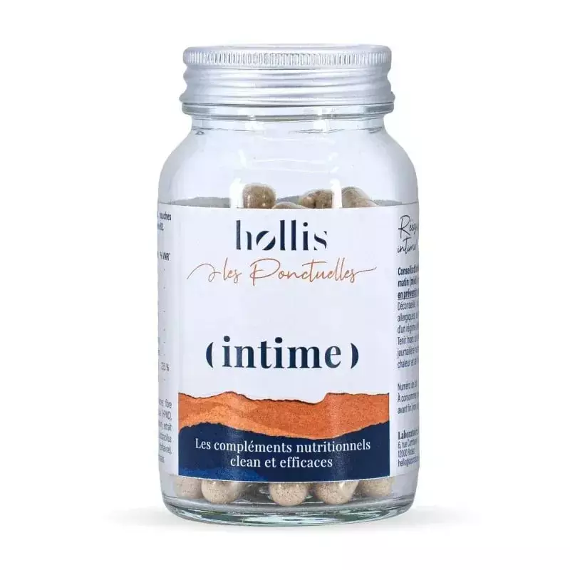 Étiquette Hollis Les Ponctuelles Intime sur un flacon en verre transparent de gélules beiges, fond b