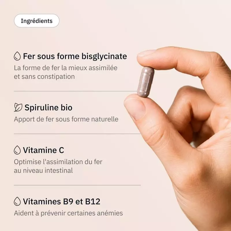 Gros plan : doigts tenant une gélule beige Hollis Fer près d'une liste d'ingrédients, fer bisglycina