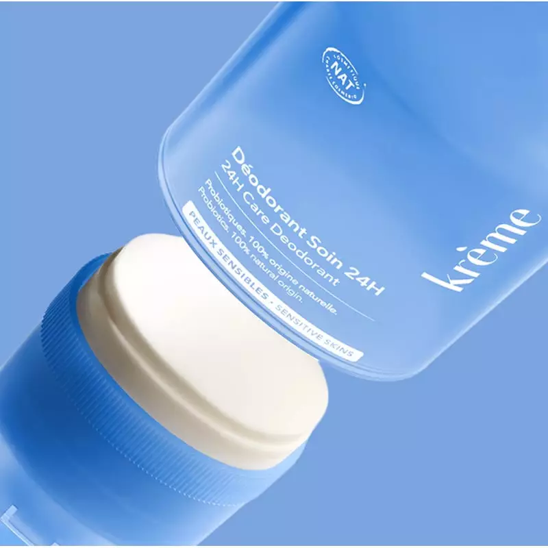 Gros plan du déodorant soin 24h Krème en stick-crème et de son capuchon bleu recyclable sur fond ble
